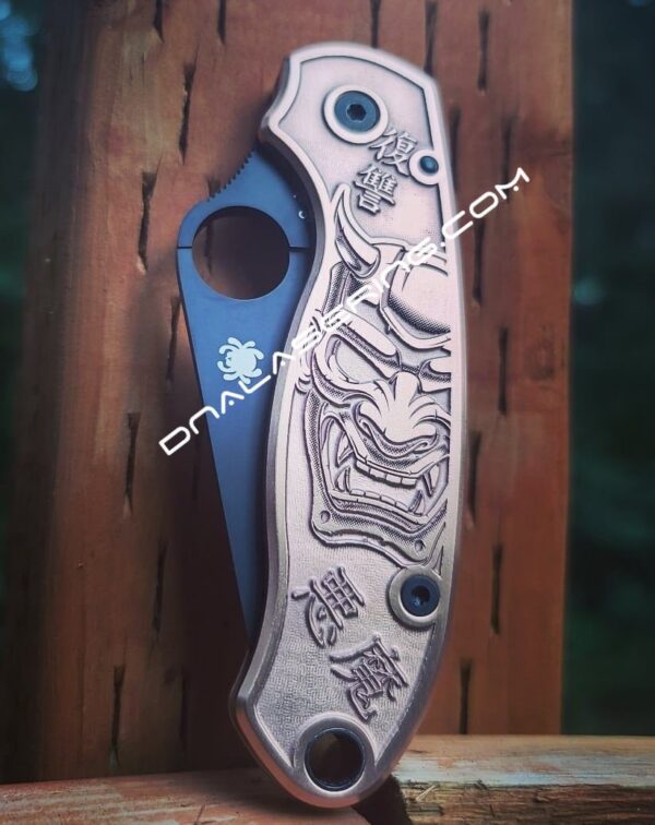 il_fullxfull.4120478110_q8fp.jpg Japanese Devil Mask - Spyderco PM3 - NEW Relief Engraving Style - Laser Engraved Copper PM3 Knife Scales - Flytanium - Knife Install Option